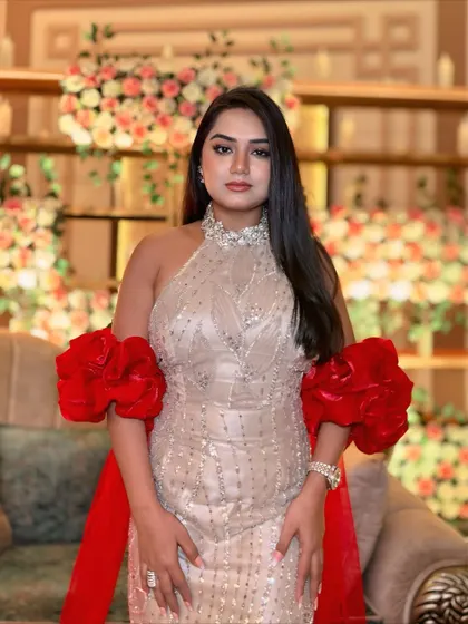 A full-frontal view of the red and beige gown, highlighting the stunning neckline and ruffled sleeves.