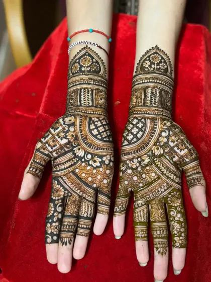 A classic design with a mix of floral, paisley, and geometric patterns, showing the fresh henna paste.