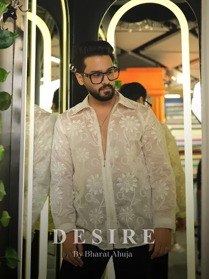 Sheer elegance meets intricate embroidery. This floral shirt is crafted from a delicate, transparent fabric with all-over white floral stitching, offering a bold yet sophisticated statement.