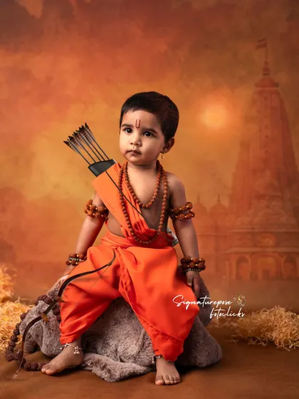 A full-body shot of a little girl embodying the grace of Lord Rama. Her confident pose and direct gaze create a powerful and memorable portrait from our Sri Rama Navami themed sessions.