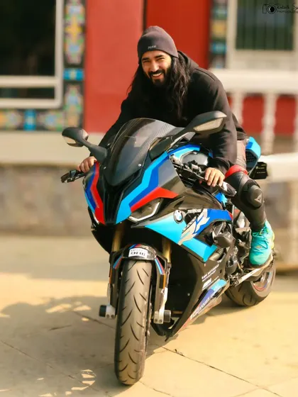 A more candid, happy shot of the rider on his BMW superbike. This image captures the pure joy and excitement that comes with riding such a powerful machine.