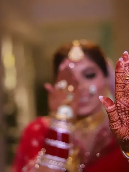 A creative bridal portrait using a shallow depth of field to draw attention to the detailed mehendi on the bride's hand.