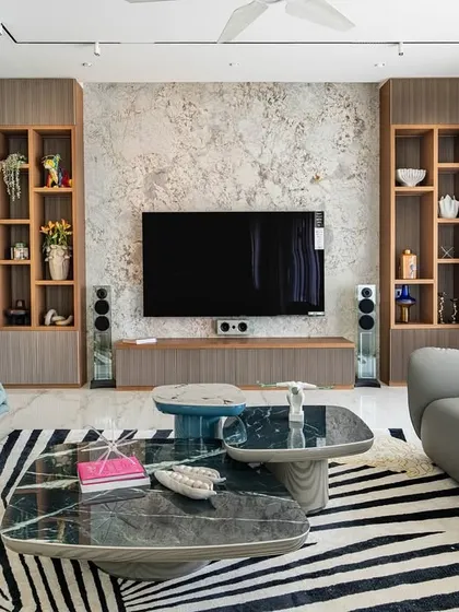 The living room from our 'Urban Oasis' project, featuring a bold zebra-print rug that anchors the space. The design mixes different textures and shapes, from the curved grey sofa to the geometric coffee tables.