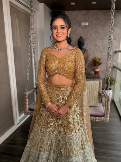 A full-length view of this stunning golden lehenga. The makeup is warm and radiant, a perfect match for the sangeet or reception event.
