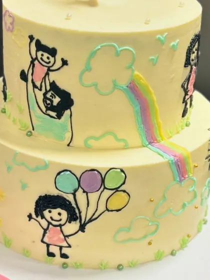 I just love how this doodle cake turned out. The two-tier design is covered in hand-painted drawings that tell a unique family story, making it incredibly personal.