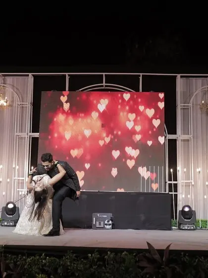 A wide shot of the couple's dance performance, showcasing the beautiful stage setup and the drama of the moment.