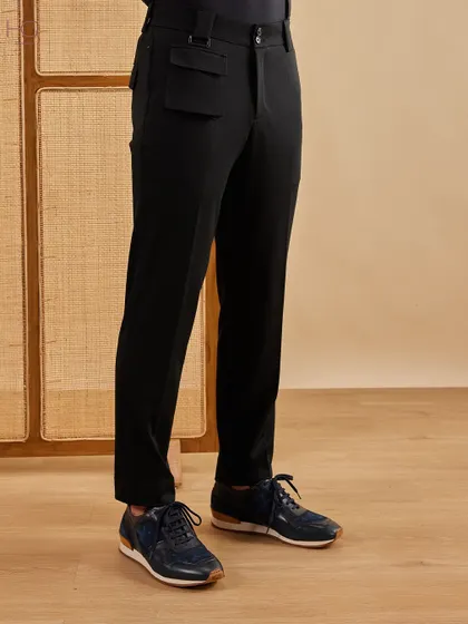 A look at the fit of my tailored black trousers, which feature a unique flap pocket detail. They are designed to create a clean, sharp line from waist to ankle.