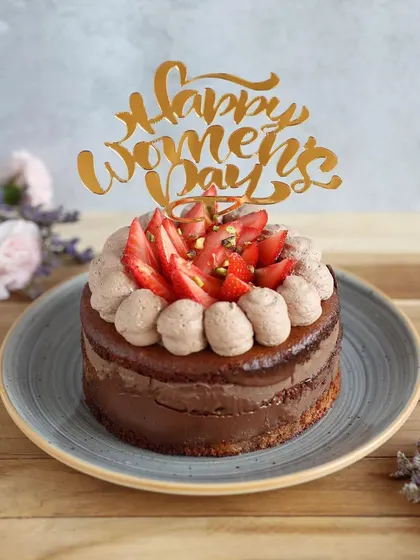 Celebrate the amazing women in your life with this beautiful Women's Day cake, topped with fresh strawberries and a "Happy Women's Day" topper.