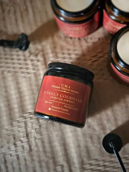 A product shot of the 'Vanilla Gourmand' candle. The amber jar and simple label give it a classic, timeless look.