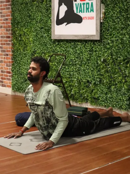 A student practices Bhujangasana (Cobra Pose), focusing on opening the chest and strengthening the spine.