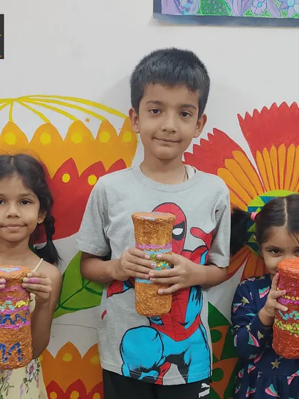 A group of proud artists with their finished rain sticks. Each one is uniquely painted, reflecting the creative spirit of its maker.