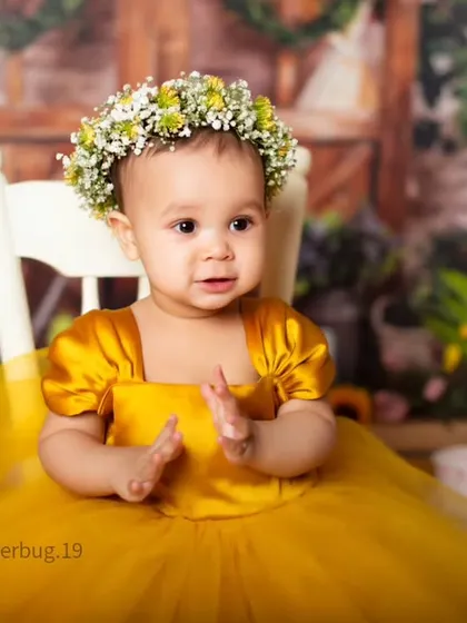 A beautiful baby girl wearing a floral crown in our bright and sunny sunflower-themed setup.