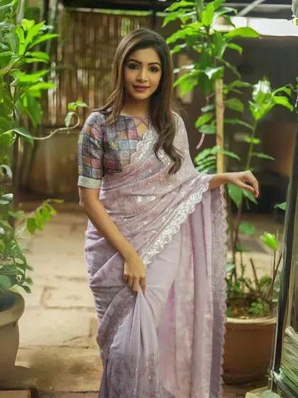 A delicate lavender georgette saree with all-over sequin work and a lace border. This is a dreamy and romantic piece, perfect for an evening celebration.
