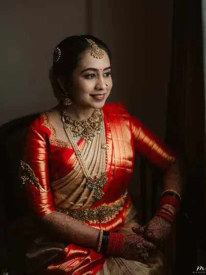 A seated portrait of the bride. Her makeup is soft and romantic, with a gentle smile that shows her comfort and confidence.