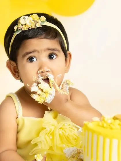 The best part of a cake smash is getting to eat the cake! This close-up shot captures the delicious and messy fun of a sunflower-themed first birthday.