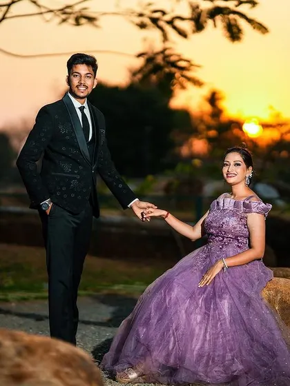 An elegant couple portrait taken during the golden hour, with the sunset providing a stunning natural backlight.