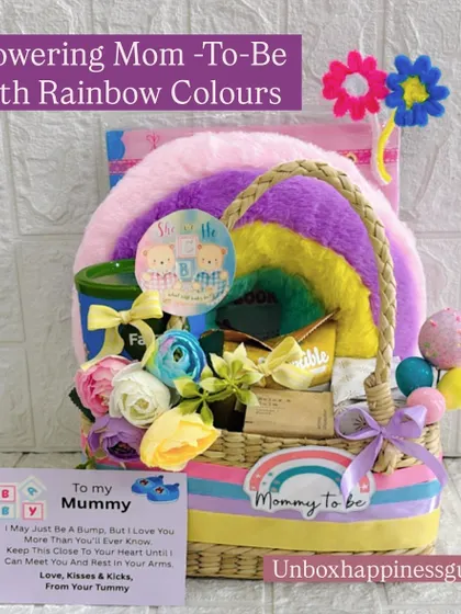 A vibrant rainbow-themed hamper designed to shower the mom-to-be with love. This basket is filled with colorful items, including a plush rainbow, decorative flowers, and a personalized card.