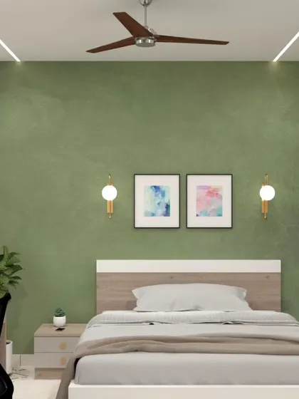 A cozy bedroom featuring a textured green accent wall that provides a calming backdrop. The room is furnished with a bed with a simple wooden headboard and an integrated desk for a compact work-from-home setup.