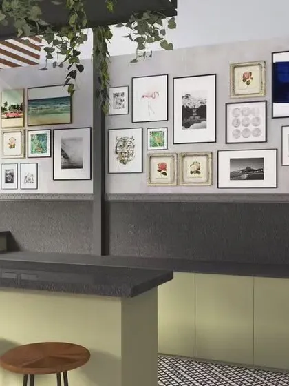 This render shows a concept for a terrace cafeteria in a co-working space. The design includes a gallery wall, hanging plants, and patterned tiles to create a quirky and relaxing outdoor-like setting.