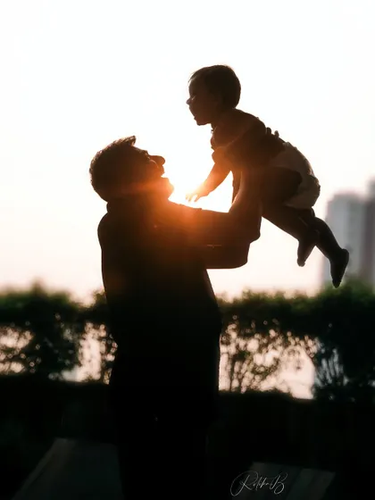 There's something so powerful about a father lifting his child to the sky. This silhouette against the sunset captures that feeling of strength, love, and endless possibility in a single, artistic frame.
