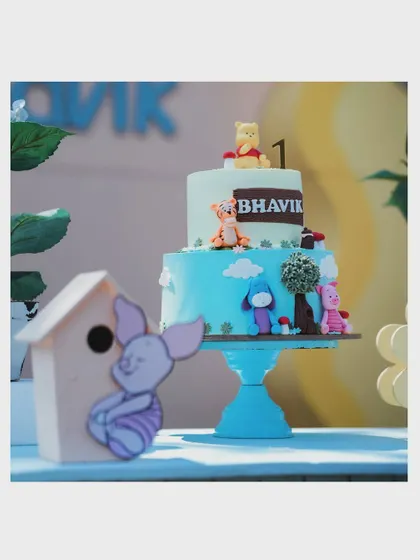 A close-up of the adorable Winnie the Pooh cake for Bhavik's first birthday, featuring all the main characters from the Hundred Acre Wood.