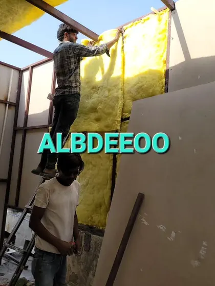 Our team installing glass wool insulation into the wall panels. This is a critical step to ensure every room we build is energy-efficient and comfortable.