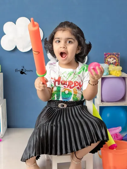 Ready for some fun. This little girl is holding a 'pichkari' and is excited to play with colors in our Holi studio setup.