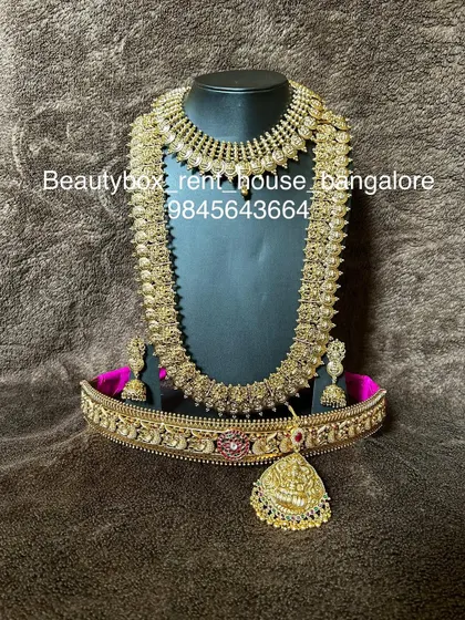 A beautiful antique coin (kasu) necklace set, including a choker, a long kasu haram, and a matching vaddanam. A very popular rental for its traditional appeal.