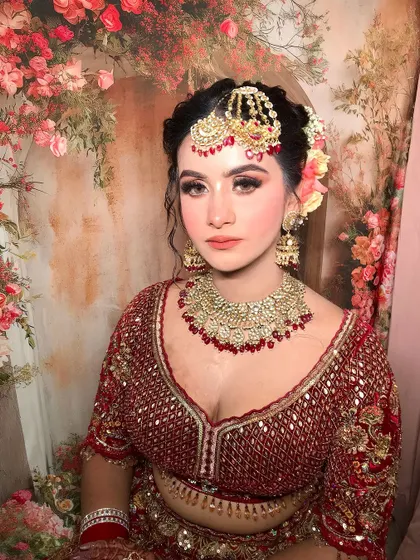 A close-up against a floral background, highlighting the coral and peach tones in the makeup.