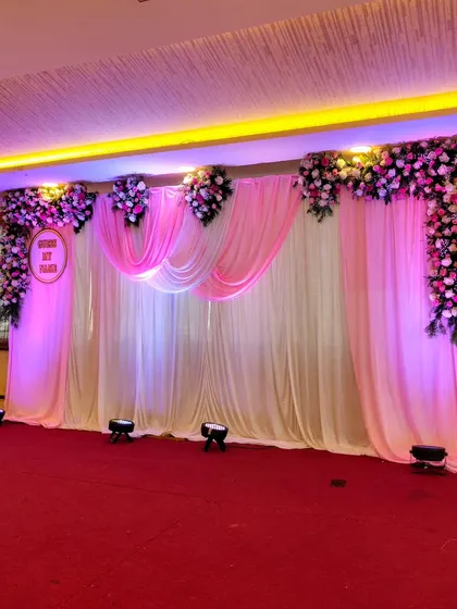 A simple yet beautiful stage with pink floral drapes and uplighting.