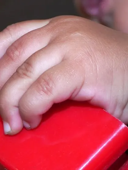 A close-up shot of a child's hand, a small detail that tells a big story. I believe in capturing all the little things that make these early years so special.