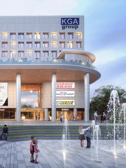 A public plaza with fountains at the KGA Mixed-Use development. This space is designed to activate the streetscape and provide a vibrant community gathering spot, shaded by structures inspired by Kerala's vernacular 'Ola Kuda' umbrellas.