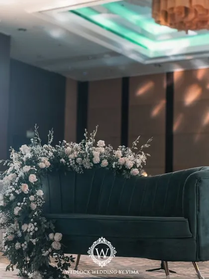 The DJ booth and dance floor for a glamorous Sangeet night. The booth is covered in lush greenery, and the ceiling is adorned with disco balls and glowing butterflies, ready for a night of celebration.