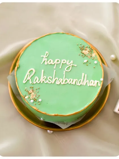 The elegant "Happy Rakshabandhan" bento cake, with beautiful script and gold sprinkles.