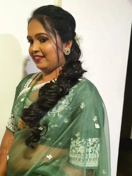 A soft, side-swept ponytail with textured waves, a great look for a guest at a wedding.