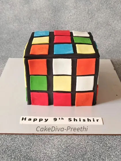 A front view of the edible Rubik's Cube. This square cake requires precise cutting and application of fondant to achieve the clean, geometric look.