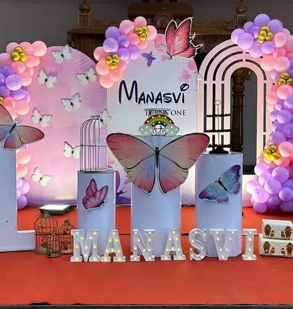 An elaborate Butterfly theme stage setup with large 3D butterfly wings, themed plinths, and marquee letters.