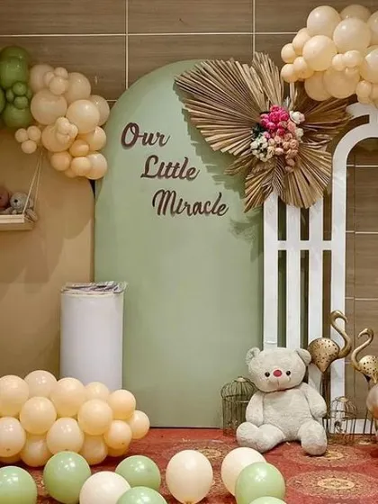 A 'Our Little Miracle' baby shower theme in earthy tones. The crescent moon prop and teddy bear create a serene and gentle atmosphere.