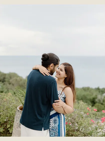 A happy, candid embrace with a beautiful ocean view in the background, capturing a moment of joy.