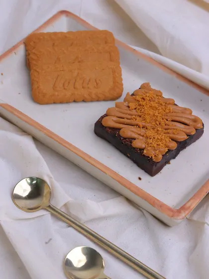 Our Lotus Biscoff Brownie served with a whole Biscoff biscuit, highlighting the key flavour inspiration for this popular treat.