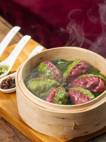 Steaming hot and ready to enjoy. Our dim sum selection, including these vibrant Mona Lisa dumplings, offers a delightful bite of Pan-Asian comfort.
