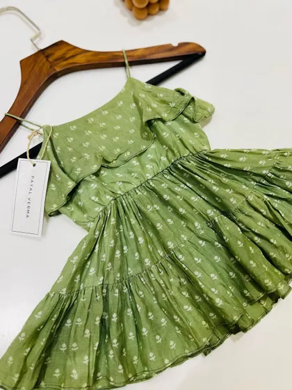 Another view of the lovely green floral dress, showcasing its simple yet elegant design. It's the perfect addition to your child's summer wardrobe.