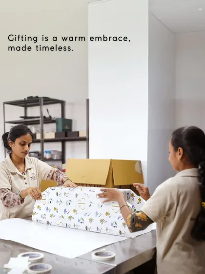 Gifting is a warm embrace, made timeless. Our team carefully wraps a large gift box, ensuring the presentation is as beautiful as the gift inside.