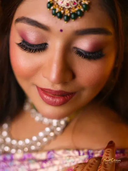 A detailed close-up of the bride's stunning eye makeup and jewelry.