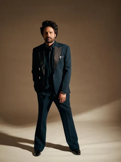 The full view of this elegant teal suit. The flared trousers and sharp blazer create a very modern and sophisticated silhouette for the red carpet.