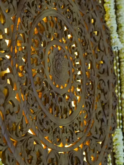 A close-up of the intricately carved wooden panels that formed the backdrop of the mandap, inspired by the art of North India and executed by artisans from Karnataka.