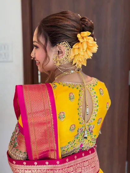 Another angle of the Khopa hairstyle, highlighting the placement of the flower and the intricate ear chain accessory.