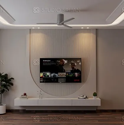 A minimalist bedroom design in Model Town, with a clean, white TV wall featuring a large, curved decorative element. The wooden flooring adds warmth to the space.