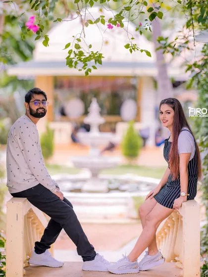 A relaxed and happy portrait of a couple on a balcony. The soft, natural light and the garden background create a very serene and beautiful atmosphere.
