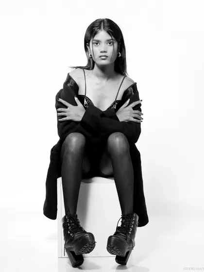 A full-body black and white shot, with a strong, confrontational pose.